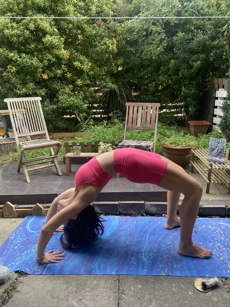 Mi reseña de la esterilla de yoga de viaje Mikkoa – Esterilla plegable para viajar Mujer en ropa de yoga rosa haciendo la postura del puente sobre una esterilla azul