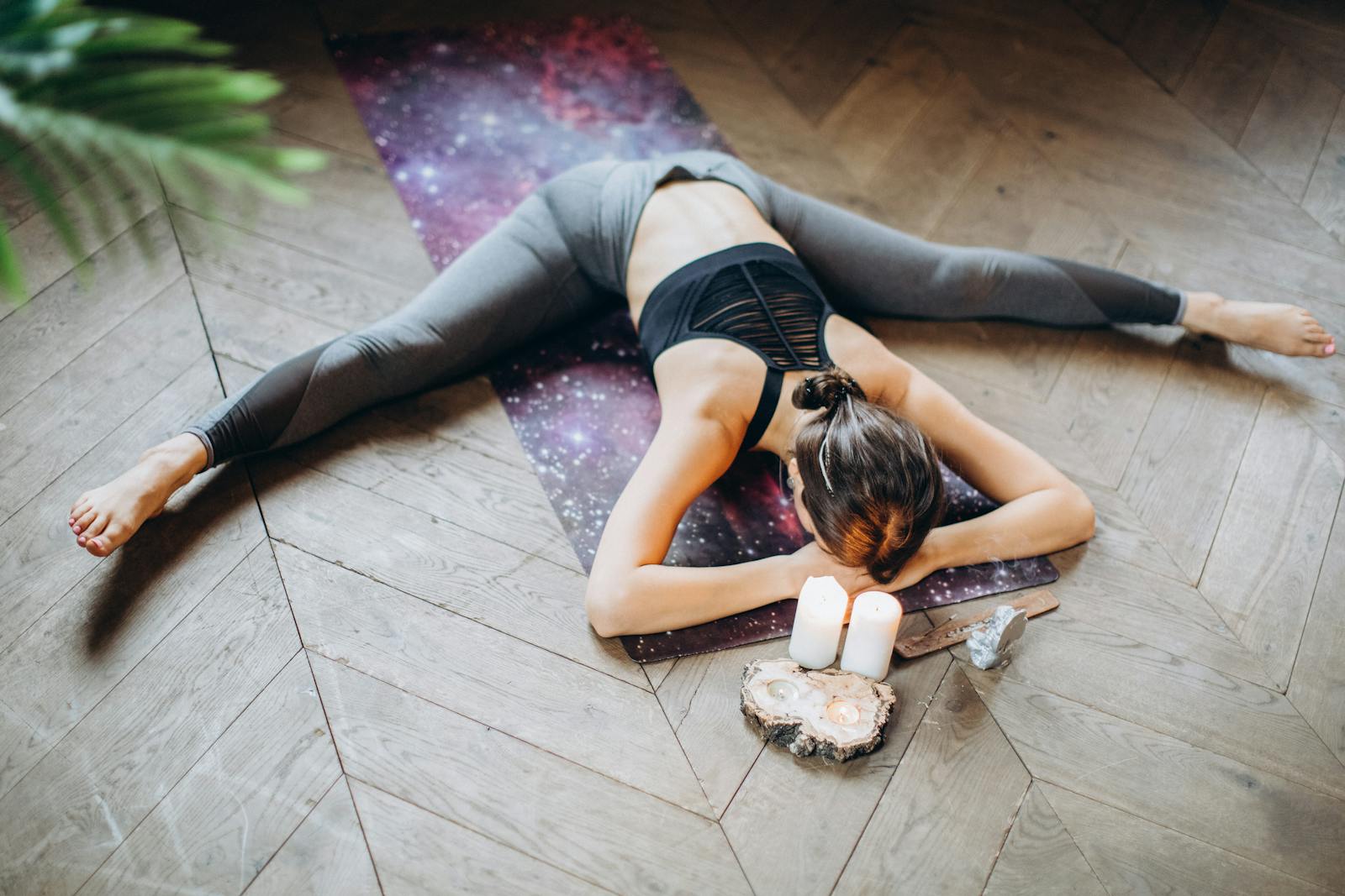 Yoga Mujer practicando yin yoga en el suelo rodeada de velas