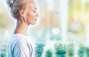 Mujer con los ojos cerrados practicando pranayama, respiración consciente para calmar el estrés