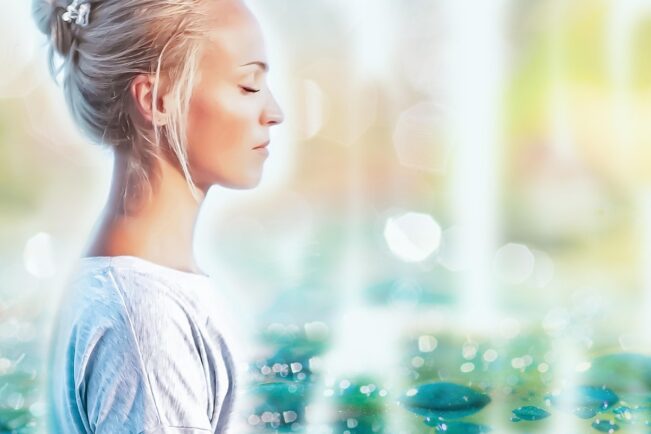 Mujer con los ojos cerrados practicando pranayama, respiración consciente para calmar el estrés